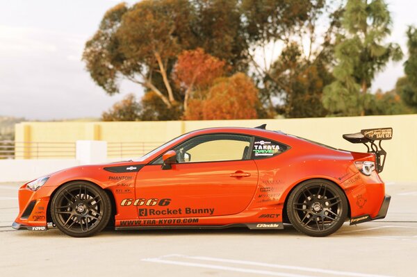 Voiture de sport orange se dresse sur la route