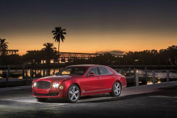 Bentley chic de couleur rouge sur fond de palmiers