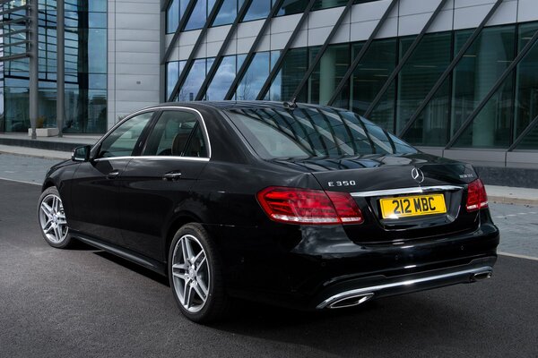 Mercedes-Benzes e 350 noir garé route à côté de l immeuble de bureaux
