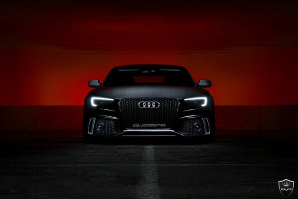 Audi noir sur fond de coucher de soleil sanglant
