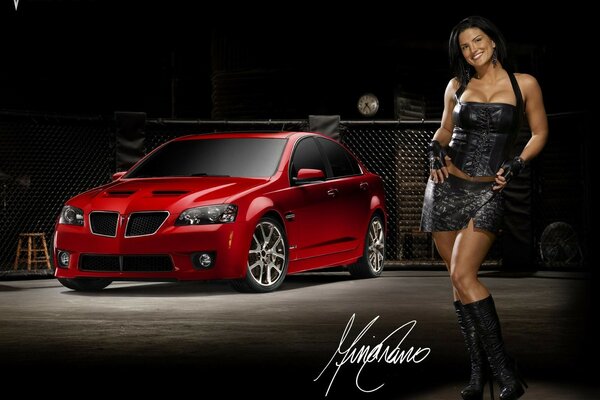 Fille en robe noire sur fond de voiture rouge