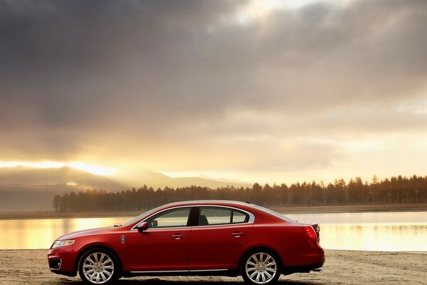 Voiture au bord du lac et sur fond de forêt