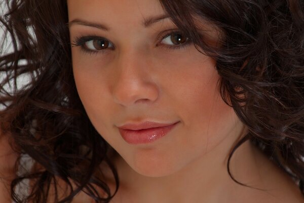 Belle fille aux yeux bruns avec des cheveux bouclés