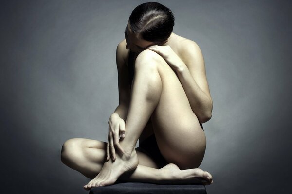 Fille assise sur le sol sur fond sombre