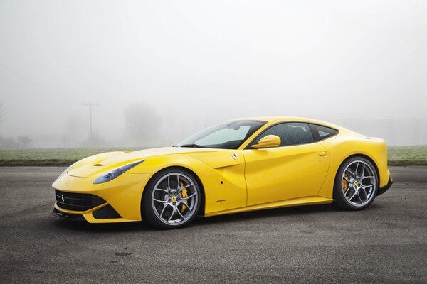 Ferrari F12 jaune dans le brouillard sur l asphalte