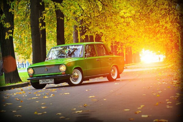 Voiture verte Lada sur fond de route d automne