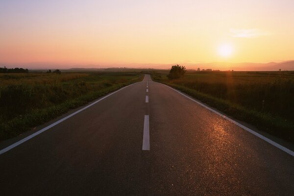 La route au coucher du soleil lointain est belle
