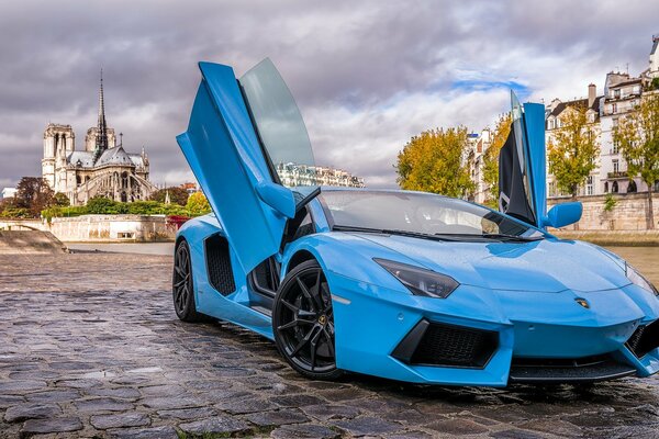 Lamborghini bleu sur le trottoir de Paris soir