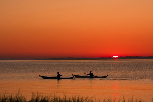 Bateaux sur fond de coucher de soleil, roseaux