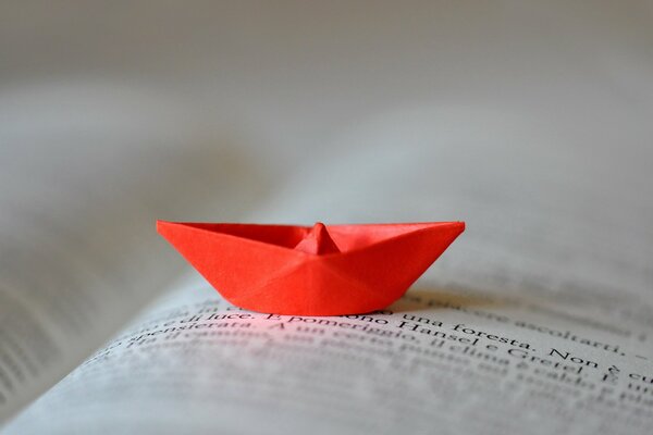 Bateau rouge de papier sur la page du livre