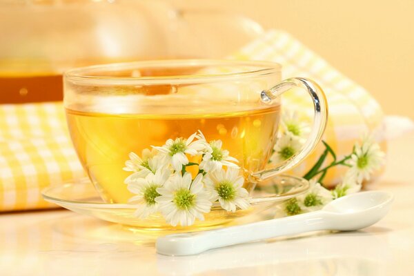 Thé dans une tasse et avec des fleurs et avec une cuillère