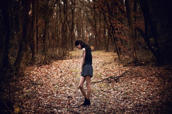 Fille en jupe courte à l automne dans la forêt sur la route