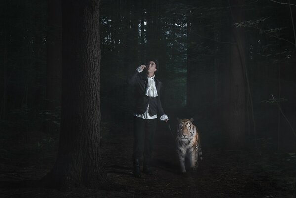 Un homme avec un tigre marchent dans la forêt