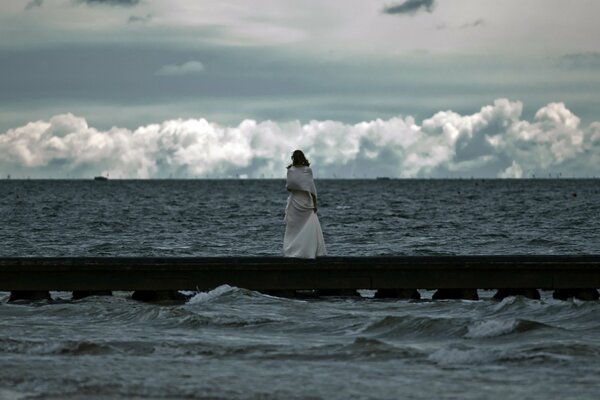 Fille regardant la mer qui fait rage