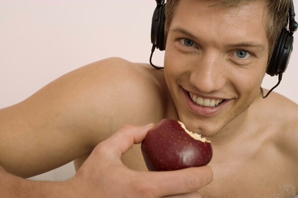Un gars dans un casque mange une pomme