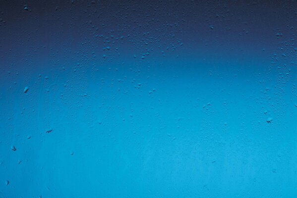 Gouttes de pluie sur fond de fenêtre bleu