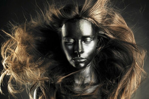 Modèle en peinture avec des cheveux dans le vent