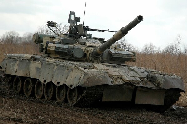 Un char militaire roule sur une route boueuse