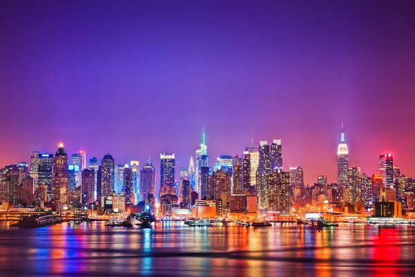 Les lumières de la nuit de Manhattan se reflètent dans la rivière Hudson