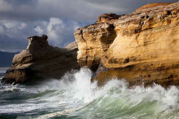 Surf marin battant sur les hautes falaises