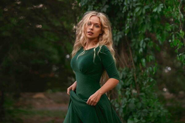 Fille en robe verte sur fond de feuillage