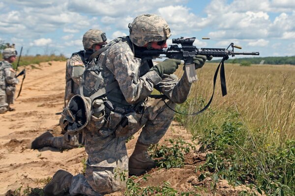 Trois soldats avec des armes sur le terrain