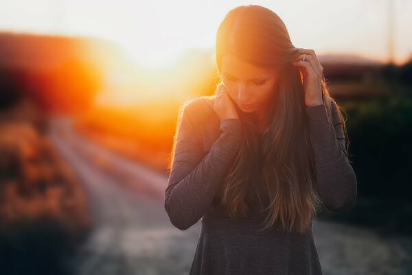 Fille réfléchie sur fond de coucher de soleil