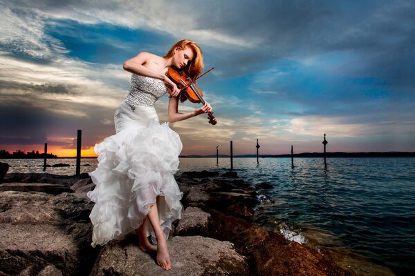 Fille en robe blanche joue du violon