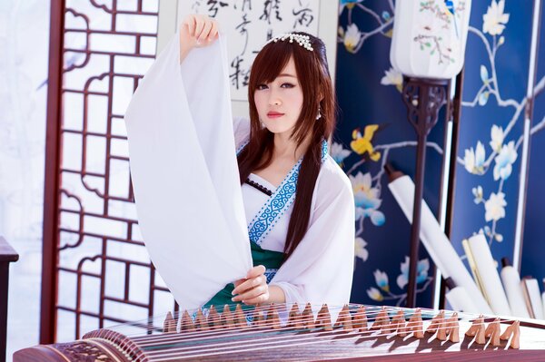 Fille asiatique en blanc avec un instrument de musique