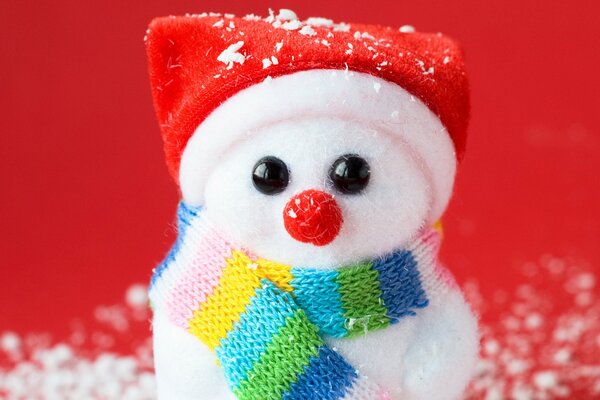Petit bonhomme de neige en bonnet sur fond rouge