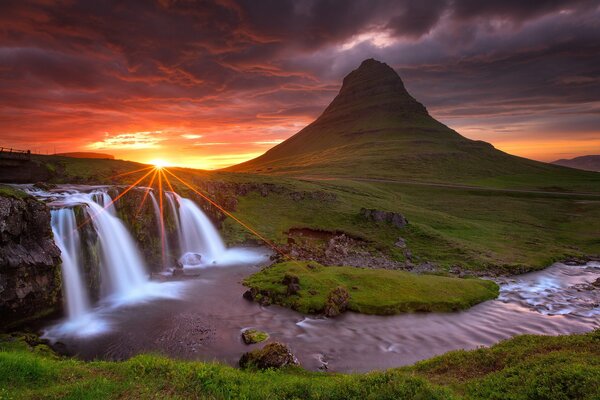 Cascade et volcan en Islande avec coucher de soleil