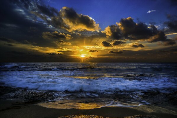 Le soleil se fraye un chemin à travers les nuages au-dessus de l océan
