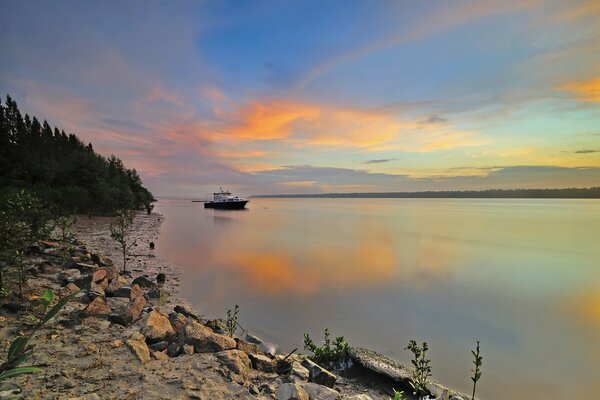 Coucher de soleil pittoresque, rivière et bateau