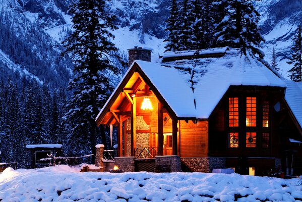 Maison dans la nature hivernale au milieu des montagnes et des arbres